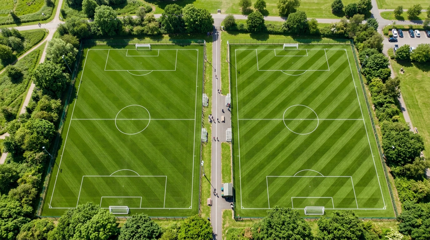 Dos campos de fútbol contiguos con césped verde divididos por una línea central blanca